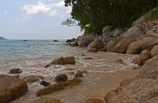 View through rocks on coastline of beach of sea,Thailand .