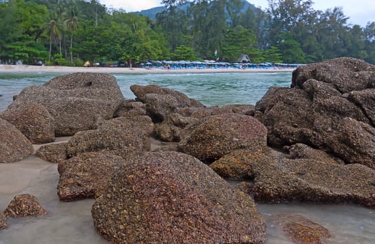 View through rocks on coastline of beach of sea,Thailand .