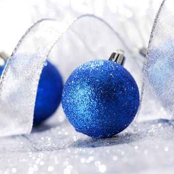 Christmas balls and ribbons decoration on shiny silver background