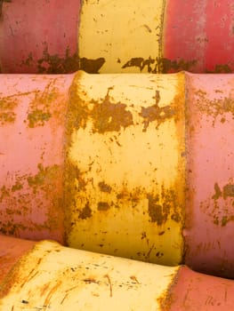 Row of rusty steel metal oil barrels yellow and red petroleum energy industry background texture pattern abstract