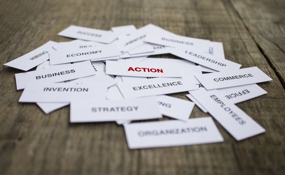 Paper strips with Action related words on wooden background