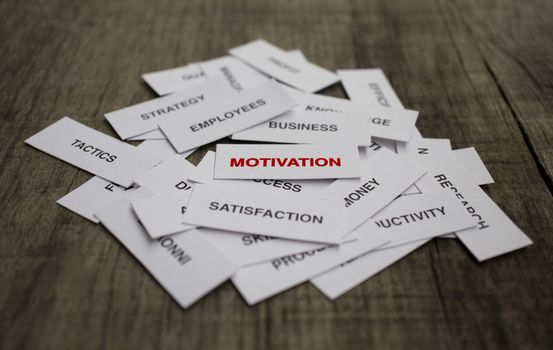 Paper strips with Motivation related words on wooden background