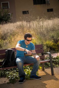 Guy filling a plastic glass with cheap wine