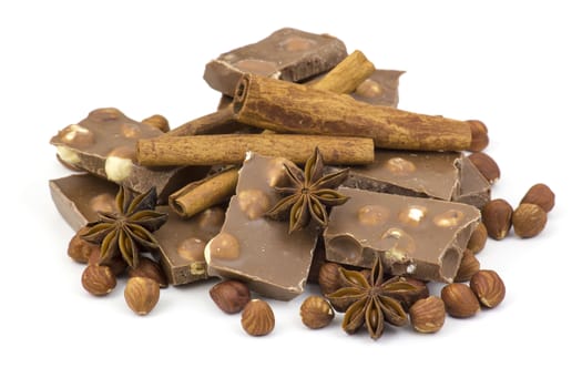 chocolate, spices and nuts on white background
