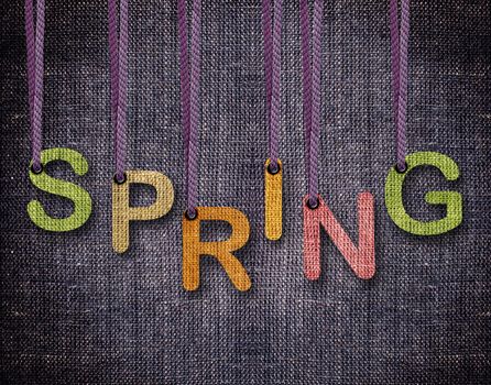 Spring letters hanging strings with blue sackcloth background.