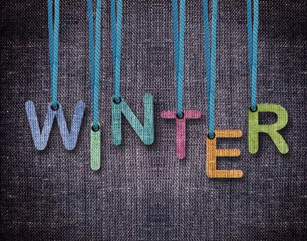 Winter letters hanging strings with blue sackcloth background.