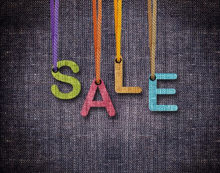 Sale letters hanging strings with blue sackcloth background.