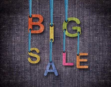 Big sale etters hanging strings with blue sackcloth background.