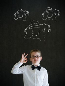 Young business boy with flying money piggy banks in chalk on blackboard background