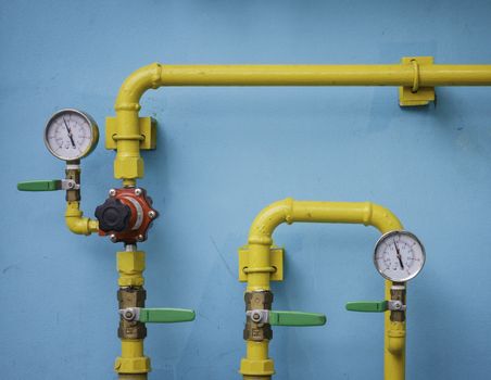 Yellow gas meter against blue wall