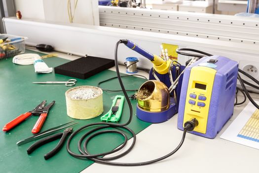 electronics equipment assembly workplace with solder and necessary tools