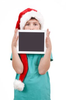 teenage boy with santa claus hat isolated on white and showing his new digital tablet 