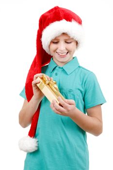 happy teenage boy with santa claus hat isolated on white and looking at his christmas gift