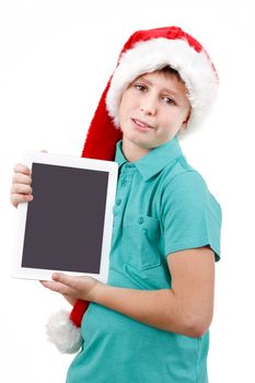 smiling teenage boy with santa claus hat isolated on white and showing his new digital tablet 