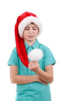 happy smiling teenager weared to red santa claus hat looking at a pompon isolated on white