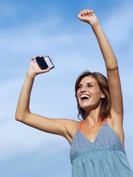 happy woman with mobile phone on sky backgroound 