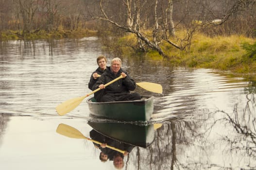 Father and son in a canoe on a riven in autumn