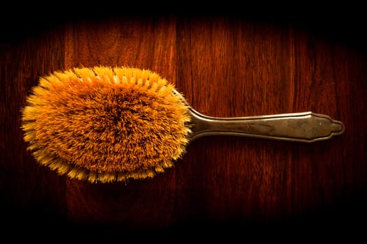 Vintage hairbrush on solid dark wood