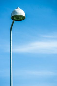 Tall streetlight lamp isolated on blue