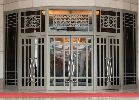 Elegant large two-leaf door in classical style with red carpet of the front