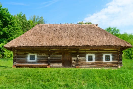 Traditional village wooden house in green country area, Eastern Europe