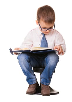 Cute clever kid in glasses read note book sitting at a chair, isolated on white background