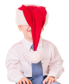 Little funny boy in Christmas red santa hat on white background