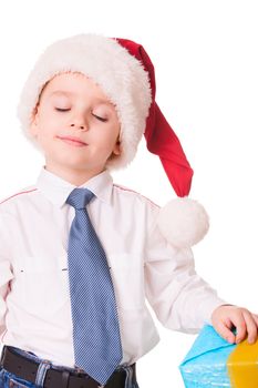 Little dreamy boy in Christmas red santa hat on white background