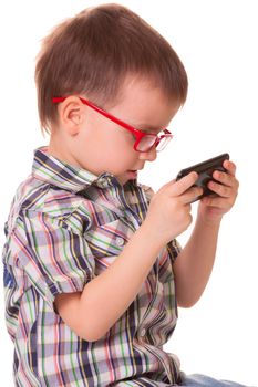 Clever kid is playing with black smart cell phone isolated on white background