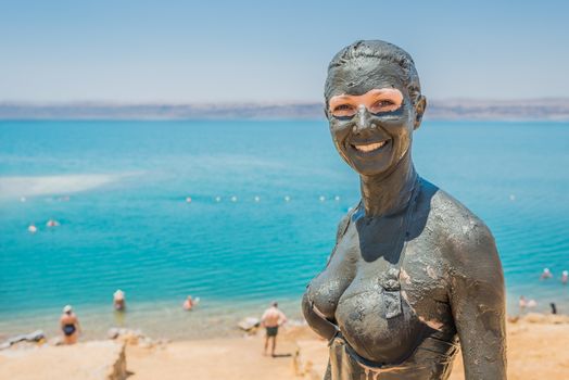 one caucasian woman applying dead sea mud body care treatment  in jordan