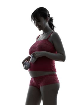 one caucasian pregnant  woman baby clothes   in silhouette studio on white background