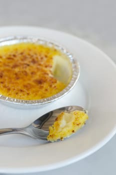 Sweet caramelized custard , French dessert - creme brulee with silver spoon over dish