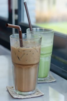 ice coffee and milk green tea with drinking straw in glass