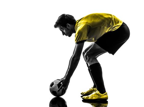one brazilian soccer football player young man preparing free kick in silhouette studio  on white background