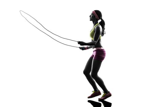 one caucasian woman exercising fitness  jumping rope  in silhouette on white background