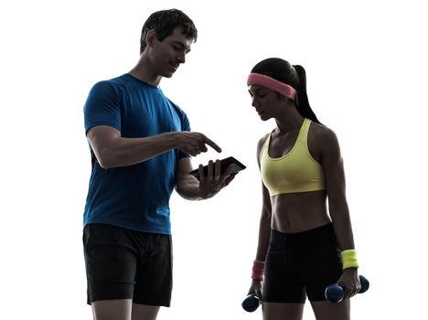 one  woman exercising fitness workout with man coach using digital tablet  in silhouette  on white background