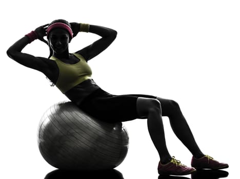 one  woman exercising crunches workout on fitness ball in silhouette  on white background