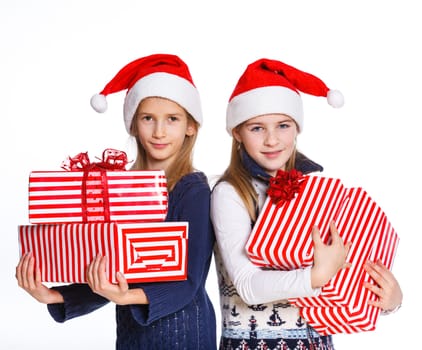 Christmas theme - Two smiling girl in Santa's hat with gift box, isolated on white