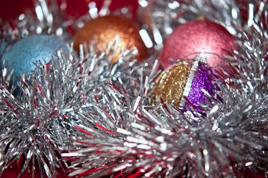 Varicoloured christmas balls on red  background  .