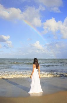 Young woman in white dress on a beach