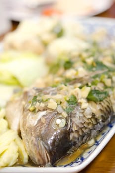 close up steamed fish with garlic , herbs and vegetable