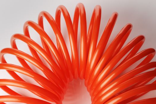 Orange red spiral plastic air hose used for pneumatic tools.