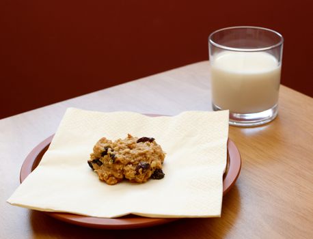 Fresh oatmeal raisin cookie served with a glass of cold milk