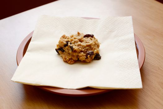 Freshly baked oatmeal raisin cookie on a napkin