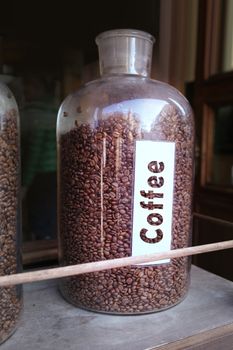 coffee grains in glass vessel on the wooden shelf