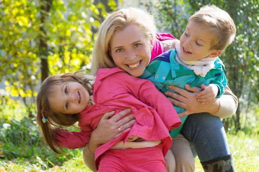 Happy mother and two children in autumn park