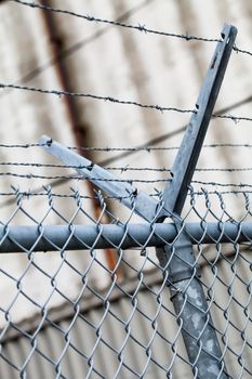 Outdoor Fence Detail of Sharp Barbwire Installation. Security and Protection Concept