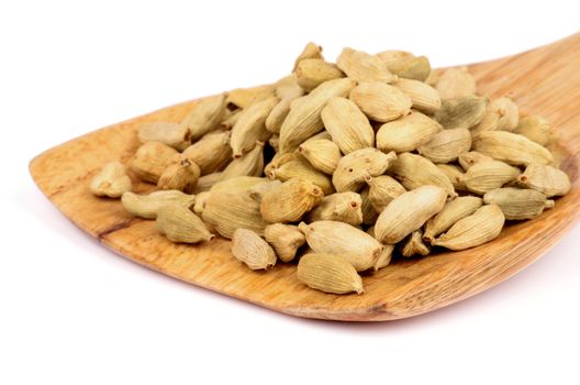 Heap of Cardamom Seeds in Wooden Spoon isolated on white background
