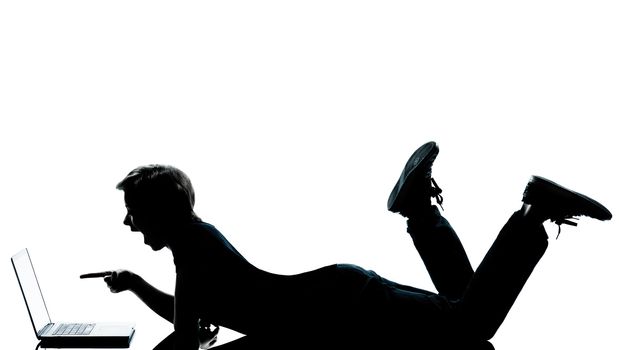 one caucasian young teenager silhouette boy girl computer computing laptop lying on front full length in studio cut out isolated on white background