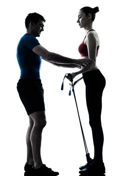 personal trainer man coach and woman exercising gymstick silhouette  studio isolated on white background